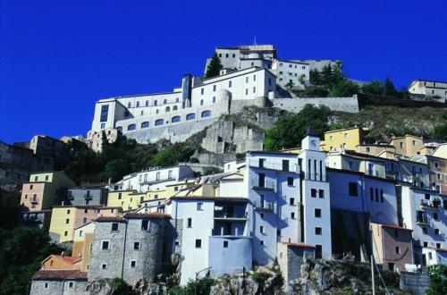 Giardino San Gerardo Maiella vista Castello e con parcheggio interno privato في Muro Lucano: مبنى ابيض كبير فوق جبل