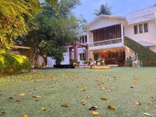 a house with leaves on the grass in front of it at Retreat by Hexa 4 Bedroom with pool and Event Space in Trivandrum