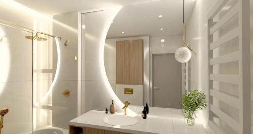 a white bathroom with a sink and a shower at Apartament pod Krasnalem in Wrocław