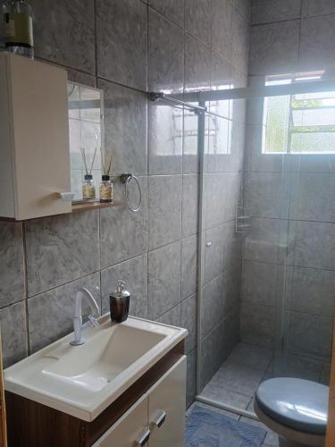 a bathroom with a shower and a sink and a toilet at Apto confortável com Churrasqueira 03 in Cachoeira do Sul