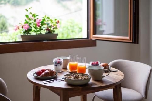 a wooden table with breakfast food and orange juice at L'Olivier in Touët-sur-Var