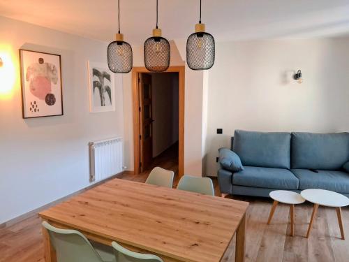 a living room with a blue couch and a table at Apartamentos Casa Domec in Castejón de Sos