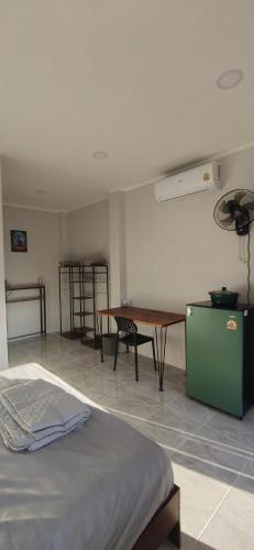 ein Zimmer mit einem Bett und einem Tisch und einem Schreibtisch in der Unterkunft Modern Bungalows in Ko Lanta Yai