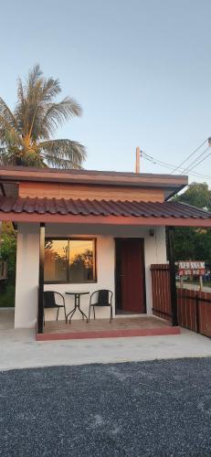 ein Haus mit einem Tisch und zwei Bänken auf einer Veranda in der Unterkunft Modern Bungalows in Ko Lanta Yai