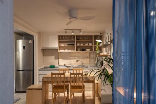Una cocina con mesa y sillas y un refrigerador. en Sogonhouse, en Seúl