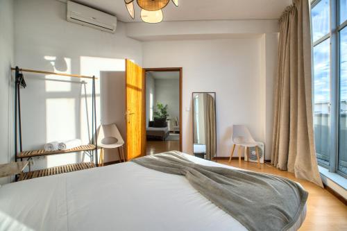 a bedroom with a bed and a large window at Apartment T1 - Porto in Porto