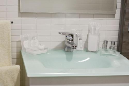 Un mostrador de baño con lavabo con artículos. en La Tarantola, en Vermezzo