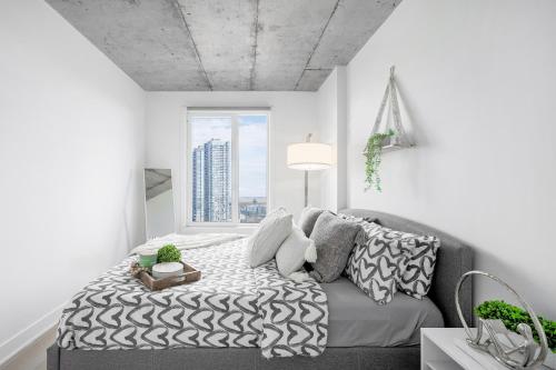 a bedroom with a bed and a large window at Cozy Oasis Home Downtown Montreal - Free Indoor Parking-In Suite Laundry in Montréal