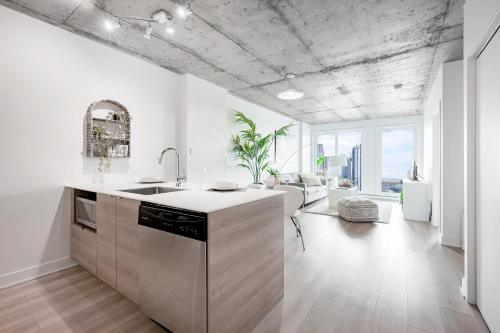 a kitchen with white walls and a concrete ceilings at Cozy Oasis Home Downtown Montreal - Free Indoor Parking-In Suite Laundry in Montréal