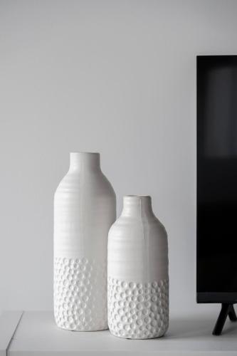 two white vases sitting on a table next to a tv at Cozy Oasis Home Downtown Montreal - Free Indoor Parking-In Suite Laundry in Montréal