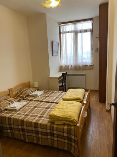 a bedroom with a bed with yellow sheets and a window at family house in Aghk'ilisa