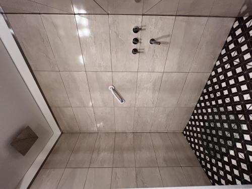 Amplio departamento renovado en el centro de la ciudad في إل كالافاتي: دش في حمام مع أرضية من البلاط