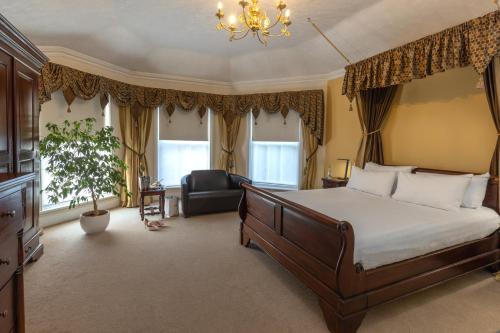 ein Schlafzimmer mit einem Bett, einem Stuhl und einem Kronleuchter in der Unterkunft Best Western Claydon Hotel in Ipswich