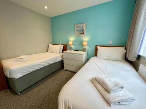 due letti in una stanza con pareti blu di Seaside Escape in Westward Ho! 3-Bed Family Holiday Home with Sea Views a Westward Ho