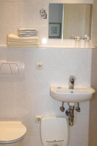 a white bathroom with a sink and a toilet at Romantic-Pension Albrecht - Villa next to UNESCO World Heritage - since 1901 in Hohenschwangau
