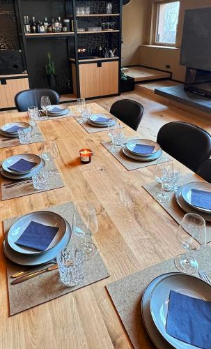 a wooden table with plates and wine glasses on it at Haus Filomena Oetz in Oetz