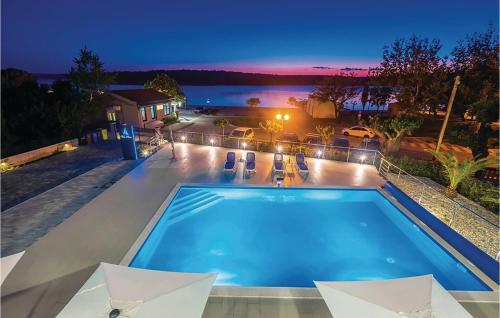 una piscina con vista sull'acqua di notte di 2 Bedroom Awesome Apartment In Punat a Punat