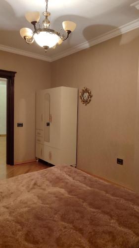 a room with a large bed and a chandelier at House in Baku