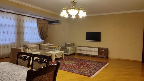 un salon avec un canapé et une télévision dans l'établissement House, à Baku