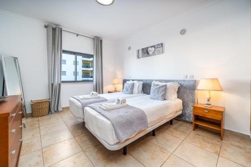 Ένα ή περισσότερα κρεβάτια σε δωμάτιο στο Central Apartment with Pools and Parking #1934