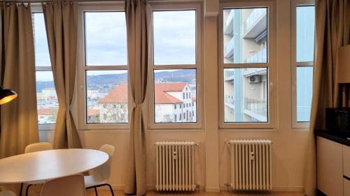 a room with windows and a table and a table and chairs at Campo Marzio 6 in Trieste