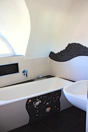 a bathroom with a bath tub and a sink at Seestern in Neuenkirchen auf Rugen