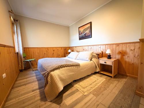 a bedroom with a bed and a wooden floor at Cabañas Anahuac II in Puerto Montt
