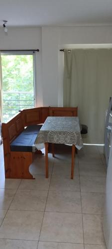 a room with a bed and a table and a window at Apartamento Monte Grande Centro in Monte Grande