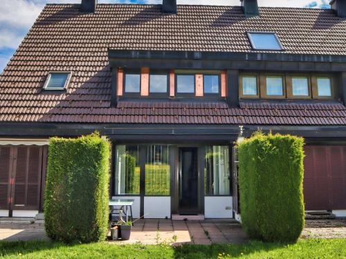 een huis met groene heggen ervoor bij Ferienhaus Hochtal in Altenrond