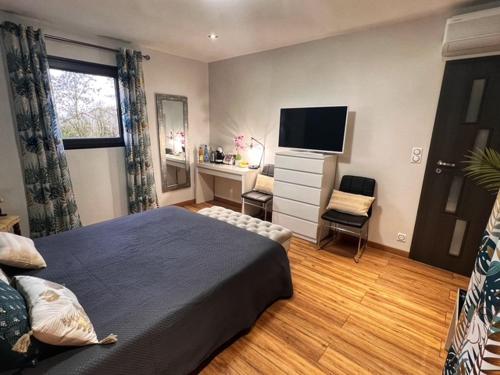 ein Schlafzimmer mit Bett, Schreibtisch und Fernseher in der Unterkunft Chambre CLAIRIERE in Maizières-lès-Metz