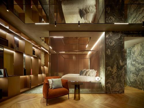 a bedroom with a bed and a chair and a table at Casa Maitò in Forte dei Marmi