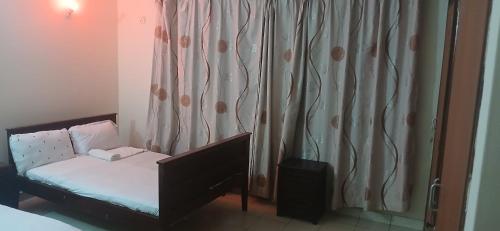 蒙巴萨Serena Beach Road Apartment的房间里有一张带窗帘的小床