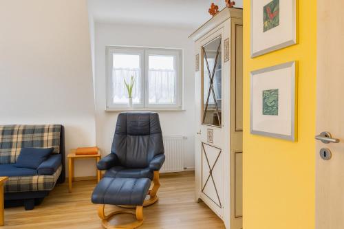 a living room with a chair and a window at Fewo Mainau in Unteruhldingen