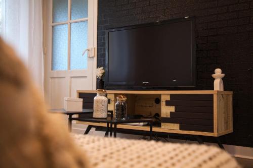 una persona sentada en una sala de estar con un televisor de pantalla plana en Escale Atlantique, en Saint-Nazaire