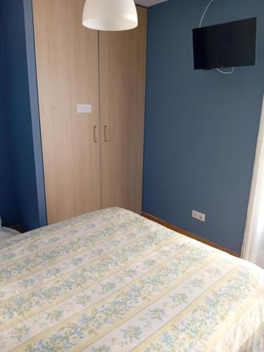 ein Schlafzimmer mit einem Bett und einem Fernseher an der Wand in der Unterkunft Chambre d'hôtes Gimont in Gimont