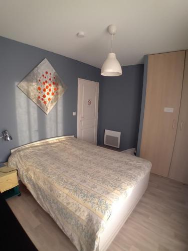 ein Schlafzimmer mit einem Bett und einem Gemälde an der Wand in der Unterkunft Chambre d'hôtes Gimont in Gimont