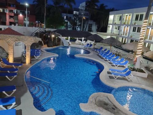 a swimming pool with blue lounge chairs and a resort at Hotel Playamar in Mazatlán