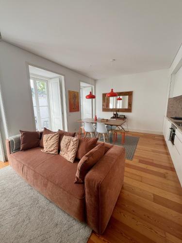 a living room with a brown couch and a table at Sol ao Castelo - Downtown w Pool, Terrace, Parking in Lisbon