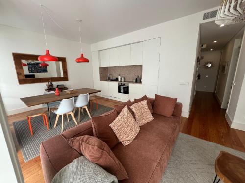 a living room with a brown couch and a table at Sol ao Castelo - Downtown w Pool, Terrace, Parking in Lisbon
