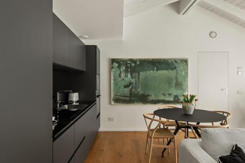 a living room with a table and a kitchen at The Golden Duo Two luxury units in one building by Aura Luxury Collection in Como
