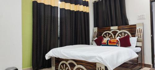 a bedroom with a bed and black curtains at Dev Guest House in Aklera