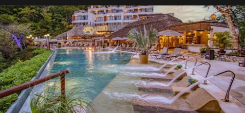 Playa Sur Paradise - Beachfront Living في سانتا كروز هواتولكو: مسبح وامامه نافورة