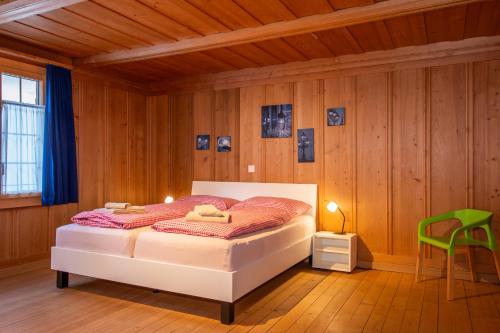 ein Schlafzimmer mit einem Bett und einem grünen Stuhl in der Unterkunft Im Zentrum in Adelboden