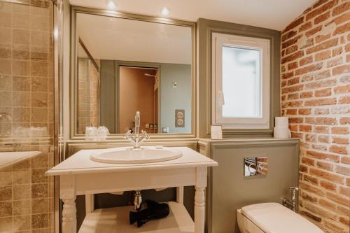 トゥルヴィル・シュル・メールにあるHôtel Saint Jamesのレンガの壁、洗面台付きのバスルーム