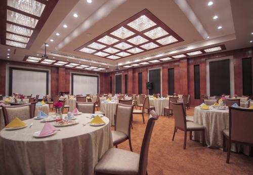 a banquet hall with tables and chairs and a large skylight at Marsa Diba Hotel in Ḑubā