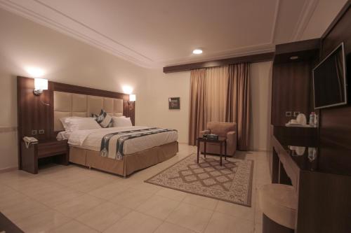 a hotel room with a bed and a chair at Marsa Diba Hotel in Ḑubā