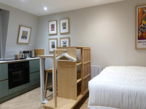 a bedroom with a bed and a table and a kitchen at Vibrant Studio Loft in the Heart of Soho in London