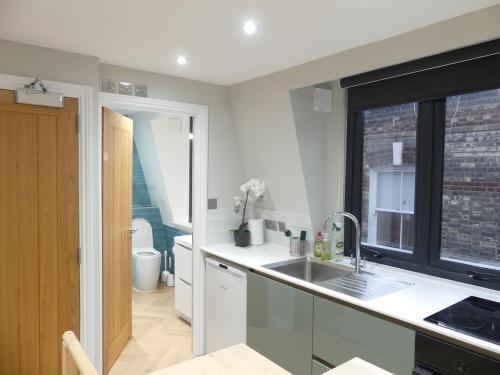 a kitchen with a sink and a window at Vibrant Studio Loft in the Heart of Soho in London
