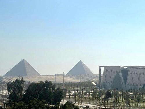 Gabry Pyramids And Grand Egyptian Museum View Hotel في القاهرة: اطلالة على اهرامات الجيزة من بعيد