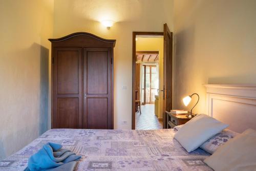 1 dormitorio con 1 cama grande y puerta de madera en Hotiday Massa Marittima, en Massa Marittima